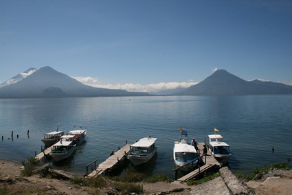 boats docked on a lake with mountains in the background