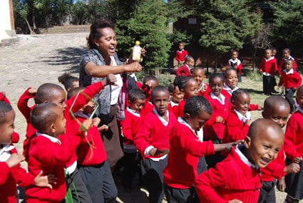 woman playing with children dressed in red sweaters