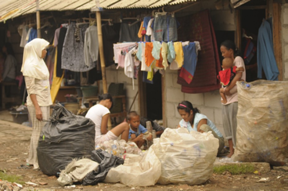 people outside house surrounded by filled garbage bags