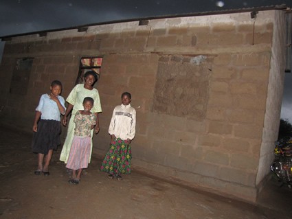 woman with three girls standing outside house