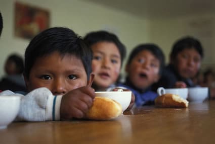 children sitting at table eating a meal