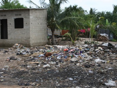 area of garbage outside of a concrete house with no windows or doors