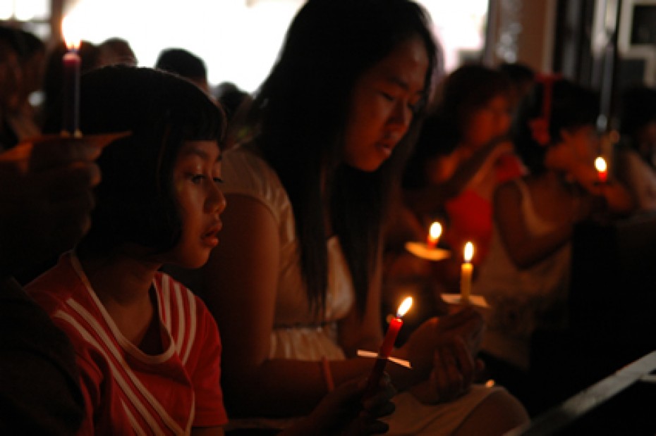 group of young girls holding candles during a service