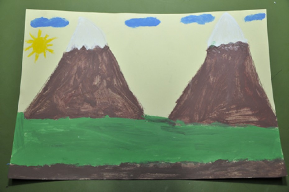 young childs drawing of green grass with two snow capped mountains
