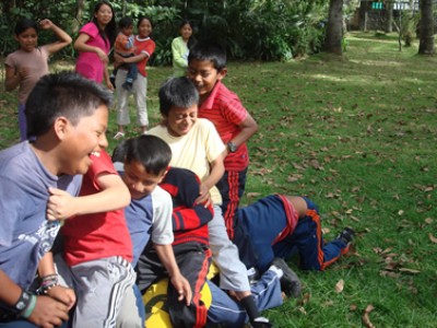 group of young children outside playing games and laughing