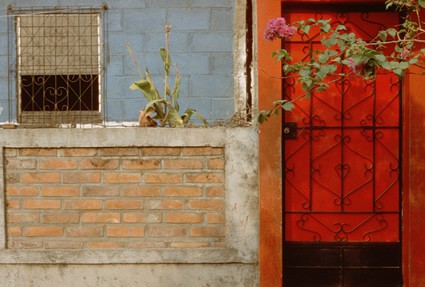 red door next to blue and brick wall