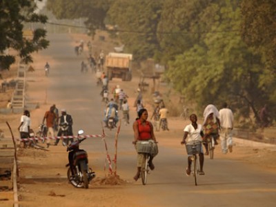 Many people riding bicycles on a rural road.