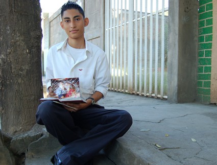 young man sitting on a step holding a photo