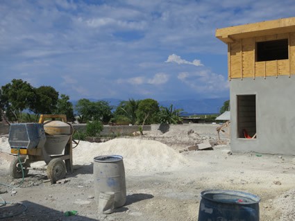 Cement mixer next to a building being built,