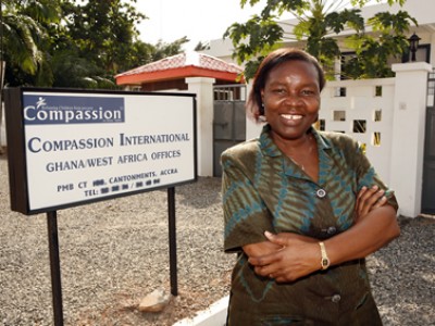 Jemima Amanor standing in front of Compassion sign