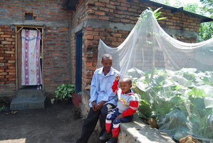 Man and child sitting outside of house