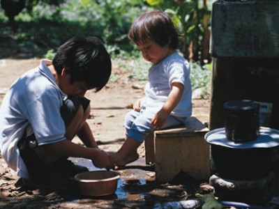 Young boy washing the feet of his little brother in Guatemala