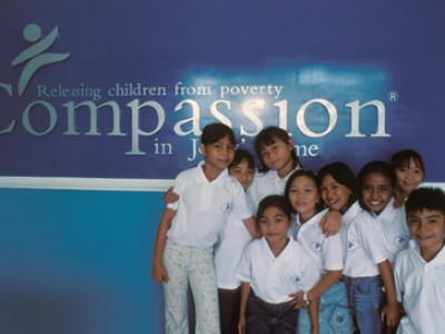 group of children in front of Compassion sign