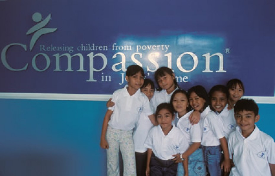 group of children in front of Compassion sign