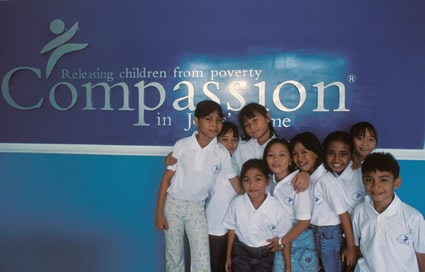 children gathered in front of Compassion banner
