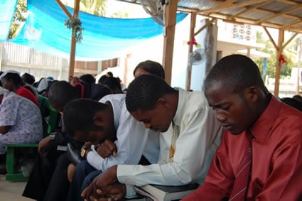 group of Haitian men praying