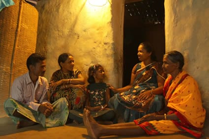 group of four adults and one child sitting on the ground