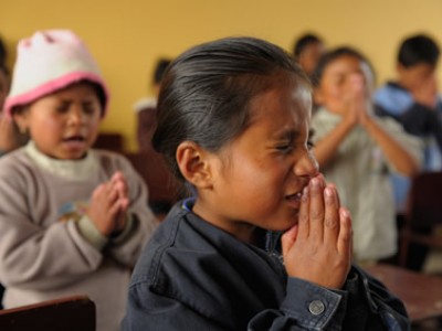 children praying in classroom