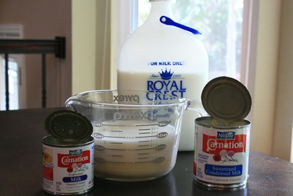three containers of different milks on a counter