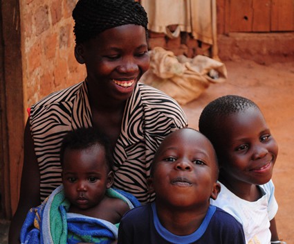 smiling woman sitting with three children