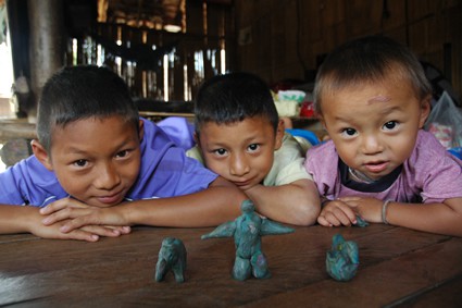 three boys showing clay figures