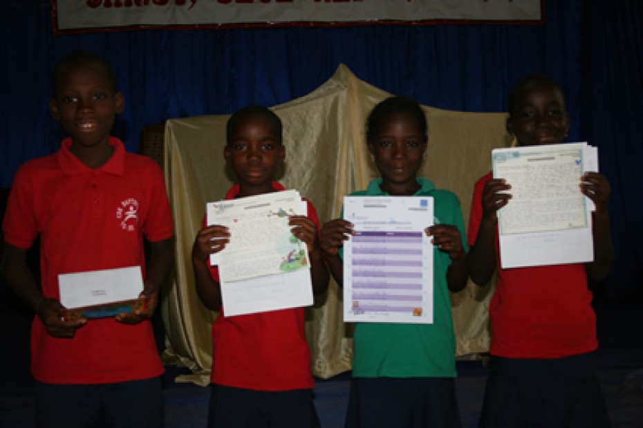 four children holding up letters