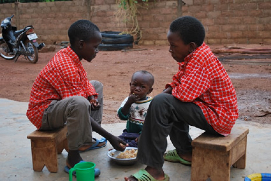 two young boys and toddler eating from dish