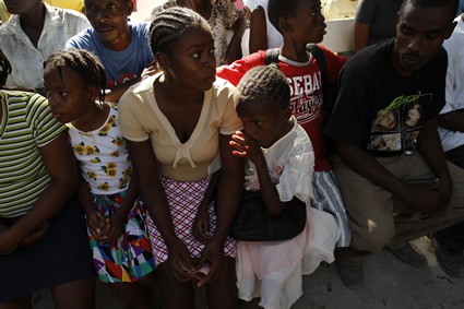 group of men and women and children sitting and waiting