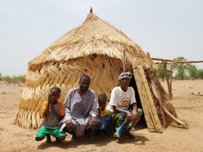 Family outside of a grass hut.