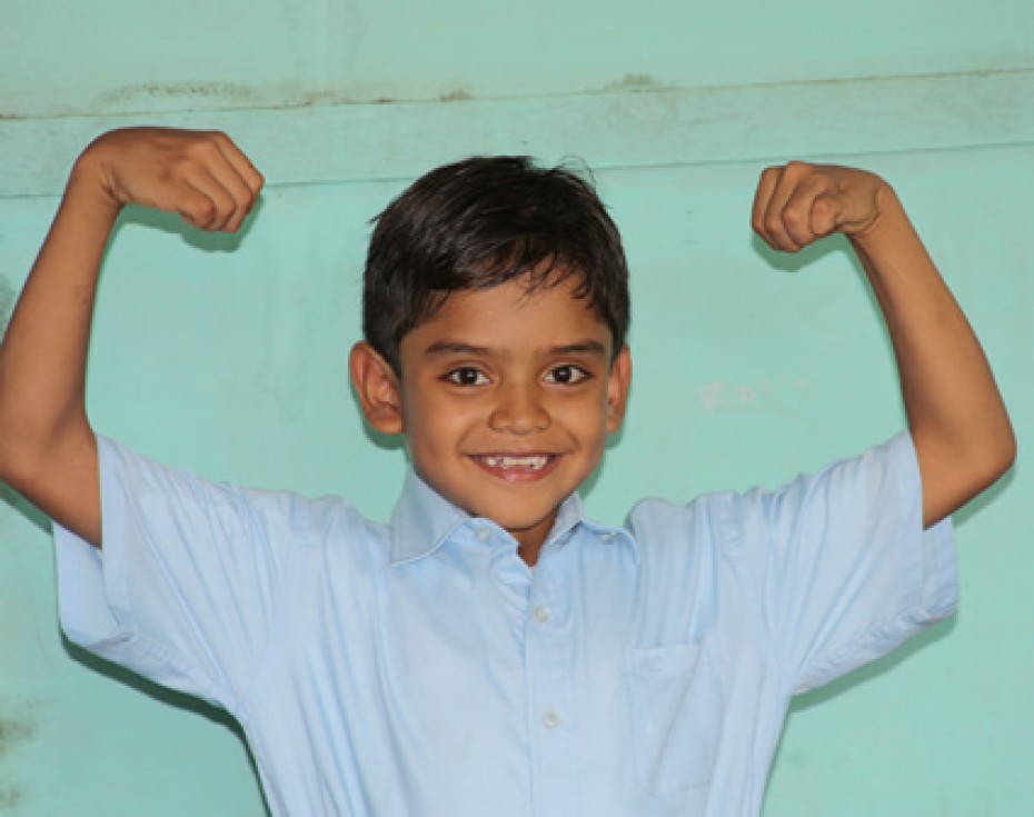 young boy flexing his muscles