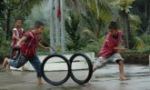 children rolling tires in a race