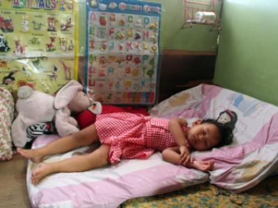 small child sleeping on mat