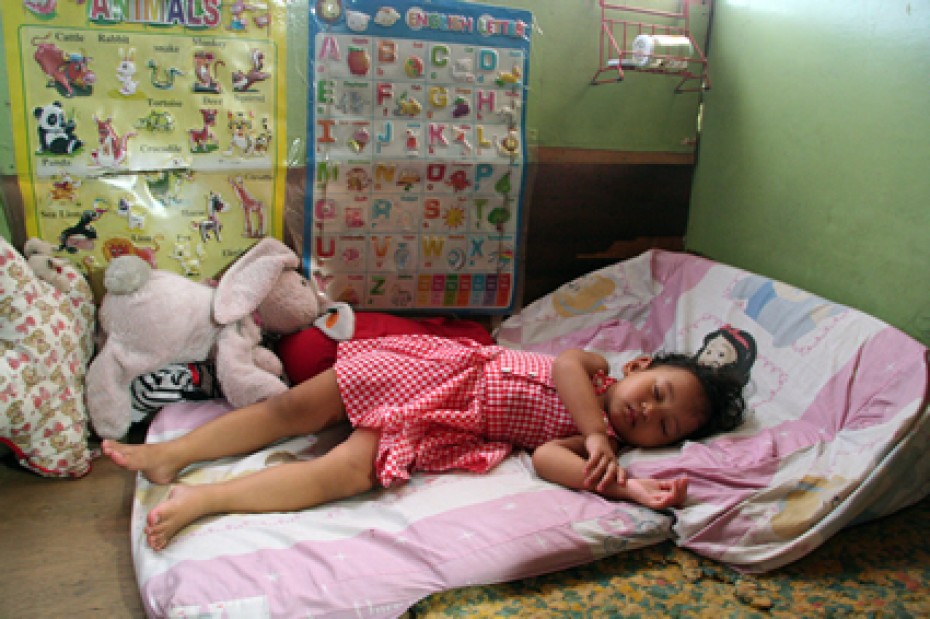 small child sleeping on mat