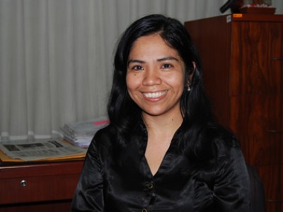 a youg smiling woman in a black blouse in an office