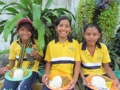 three girls holding plates of food