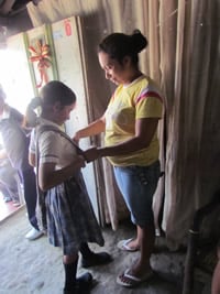 woman helping girl get dressed