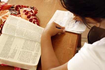 person reading Bible and taking notes