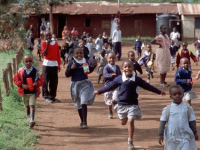 school children running down road in Kenya