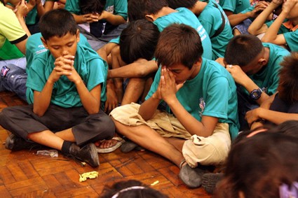 children sitting on floor praying