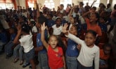 group of children with hands raised inside a church