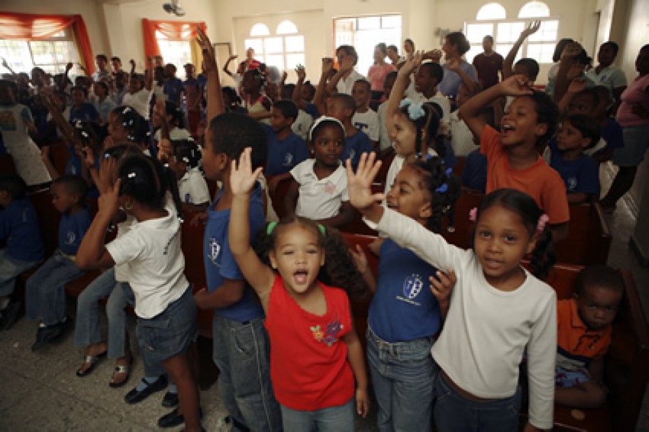 group of children with hands raised inside a church