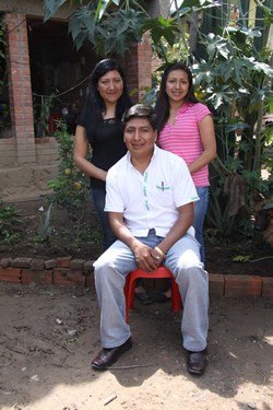 boy sitting with woman and girl standing behind him