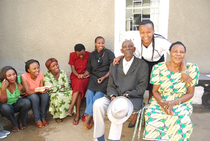 group of smiling women honoring an elderly couple