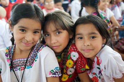 three smiling girls wearing traditional dress