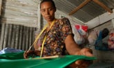 A mom measuring fabric in the Dominican Republic