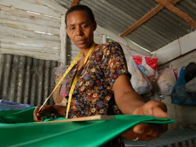 A mom measuring fabric in the Dominican Republic