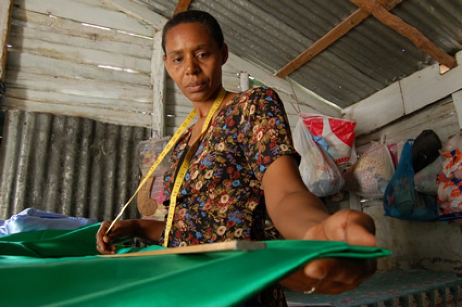 A mom measuring fabric in the Dominican Republic