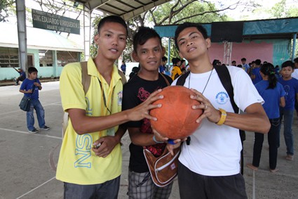 three young men holding a basketball