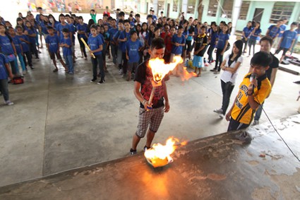 large group of children watching a torch lighting ceremony