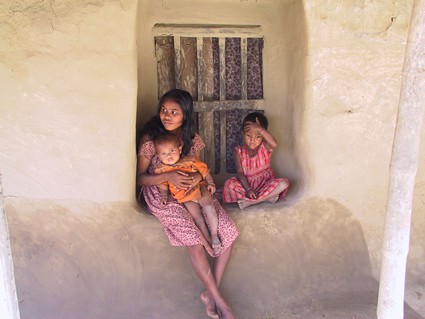 woman sitting with two small children in window ledge